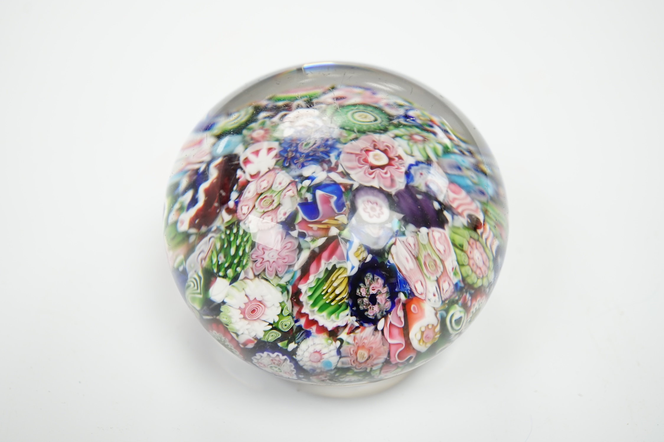 A Clichy scrambled glass paperweight with unusual pink and green rose, 6.5cm in diameter